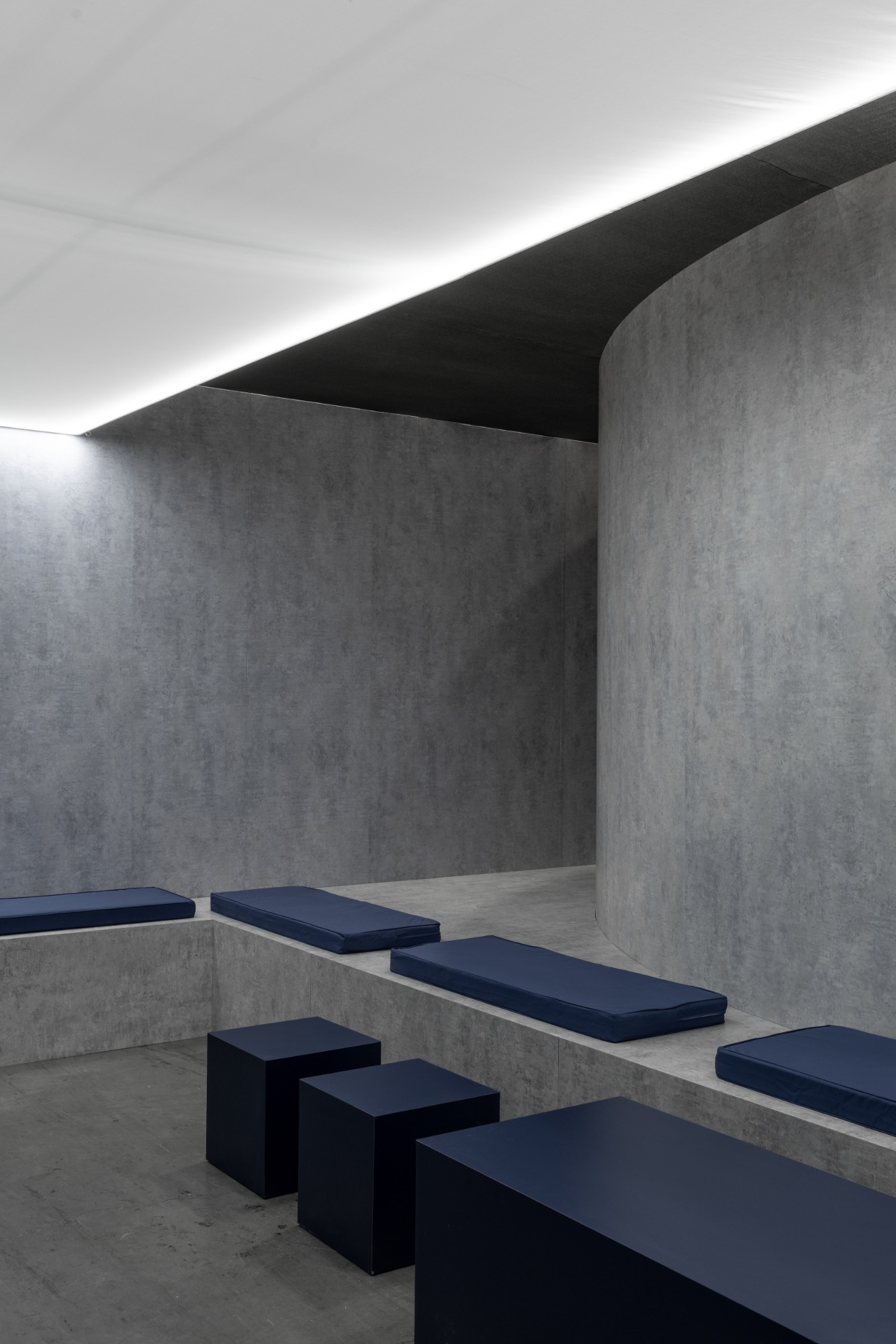 Navy upholstered benches and block seats along a curved wall