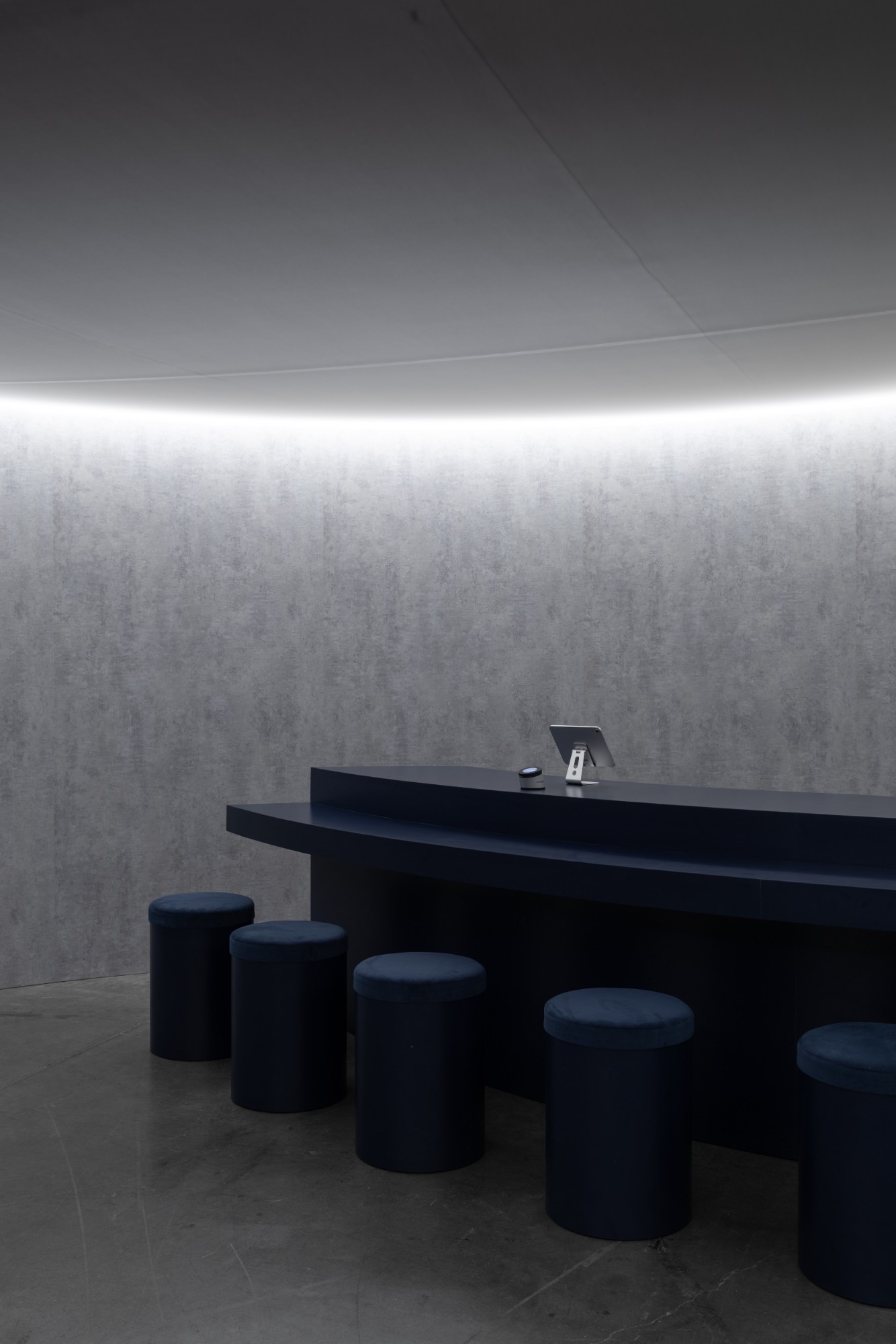 Velvet stools lined up at the curved sushi bar