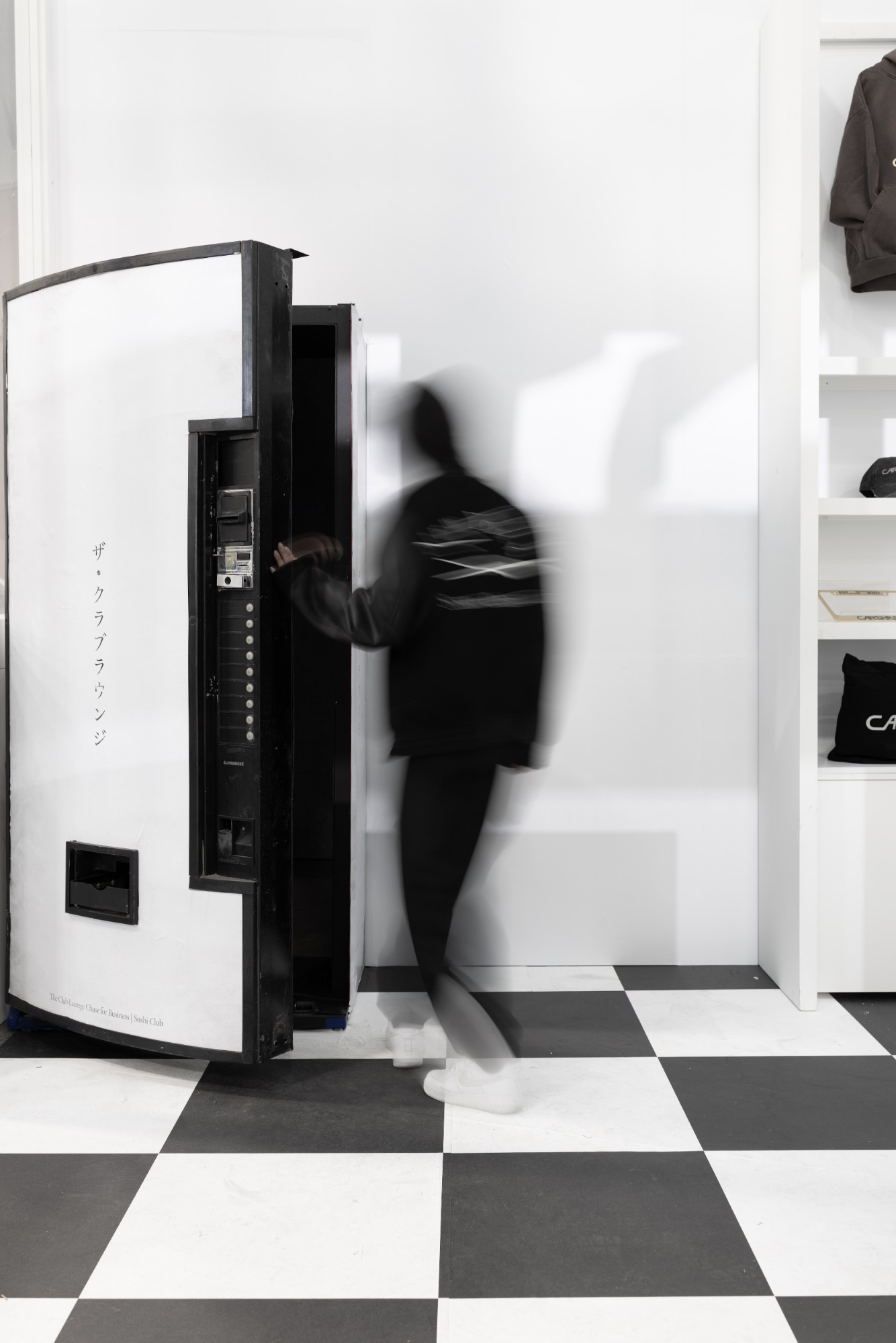 A guest pulls open the hidden vending-machine door to the Club Lounge at ComplexCon 2025